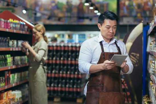 Pemilik toko retail mengembangkan bisnis dengan menata produk dan mengelola area penjualan